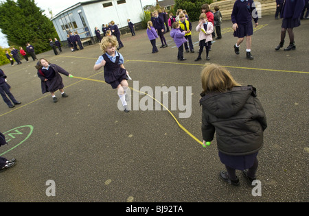 Skipping, traditional school playground game being played on the schoolyard of a primary school in Wales UK Stock Photo