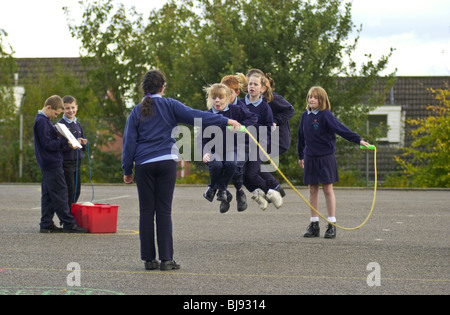 Skipping, traditional playground game being played on the schoolyard of a primary school in Wales UK Stock Photo