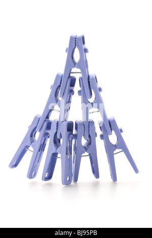 Plastic clothes pegs assembled in shape of pyramid on white background Stock Photo