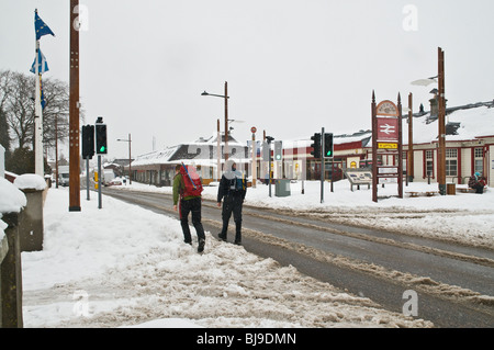 dh  AVIEMORE INVERNESSSHIRE Tourist backpackers walking winter snow Aviemore holiday ski resort Stock Photo