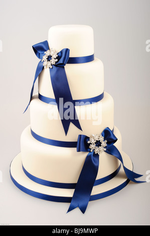 Four tiered cake with royal blue ribbons in bows with diamond center Stock Photo