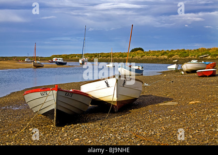 Boats beached at low tide in the natural harbour at Overy Staithe Norfolk Stock Photo