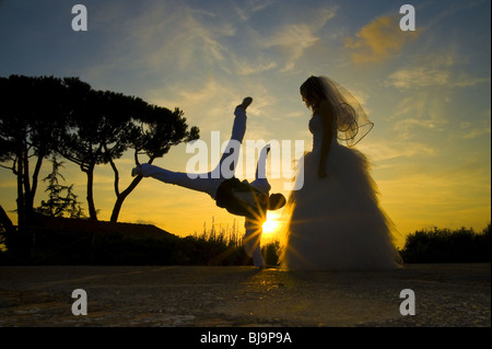 Groom celebrating marriage with a Capoeira stance at sunset Stock Photo