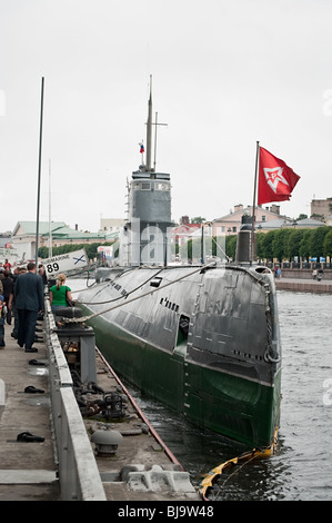 Russian diesel submarine with red flag, hammer and sickle. Boat moored in Saint-Petersburg port. Stock Photo