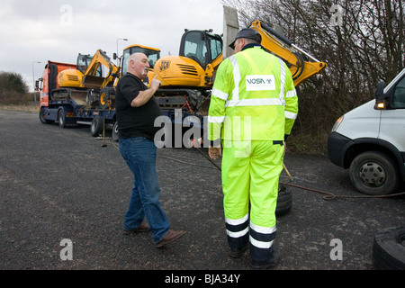 A Lorry Driver Talking To A VOSA Officer at checkpoint in Cambridgshire Stock Photo