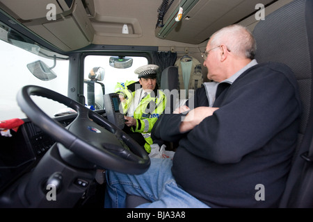 A Police Officer talking To A Lorry Driver in his cab Stock Photo