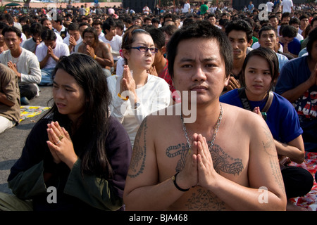 A young man in prayer during Wai Kru Day at Wat Bang Phra, a Buddhist temple in Thailand where monks tattoo devotees. Stock Photo