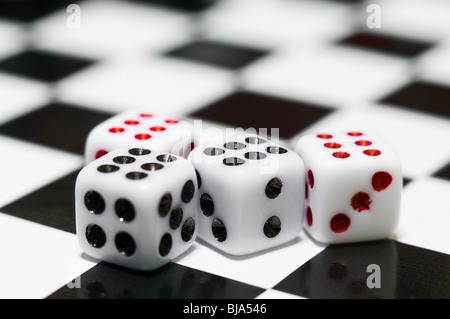 Playing dices with six numbers on chessboard surface Stock Photo