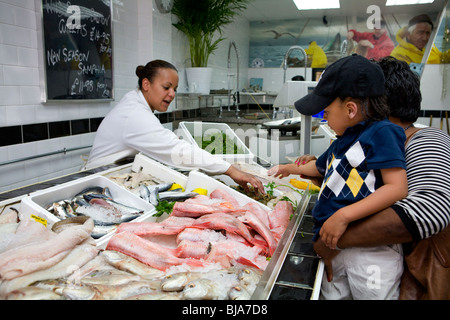 young boy looking at the seafood on display at local fishmonger's Stock Photo
