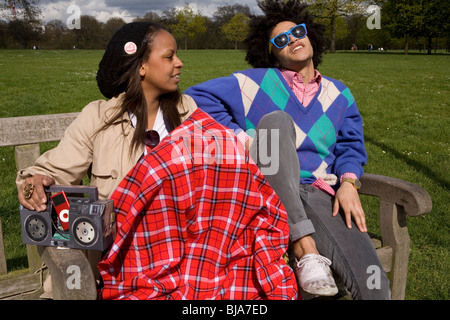 young cool couple relaxing on park bench Stock Photo