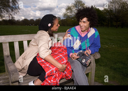 young cool couple flirting on park bench, flash Stock Photo
