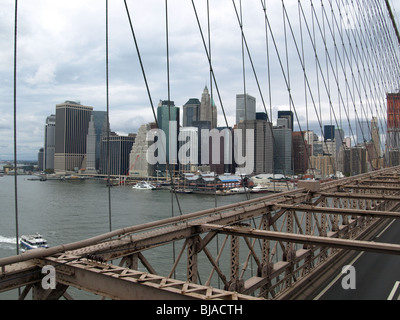 Brooklyn Bridge New York Skyline. View from  pedestrian walkway looking through 'Bridge supporting Stays'.  Traffic  road under Stock Photo