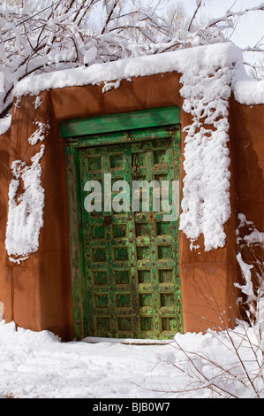 Ornate wooden doorway in adobe wall in Santa Fe New Mexico Stock Photo