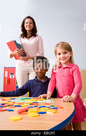 Two young children in kindergarten with teacher Stock Photo
