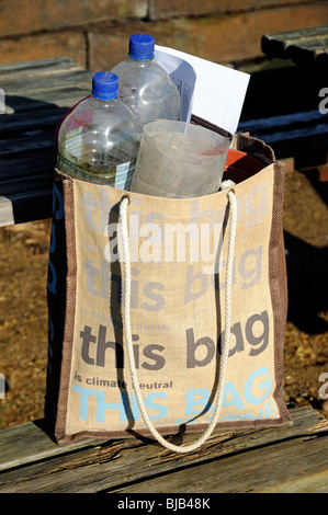 Reusable cotton bag with this bag is Climate Neutral printed on the front and plastic bottles used as cloches inside Stock Photo
