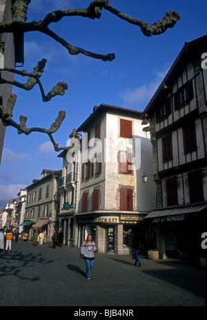 French people young adult woman walking along Rue Gambetta in the French Basque Country in the town of Saint-Jean-de-Luz Stock Photo