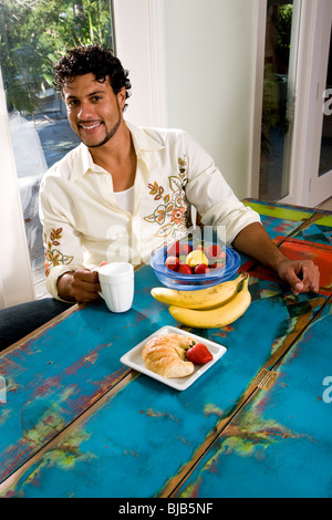 Young Hispanic man having coffee and breakfast Stock Photo