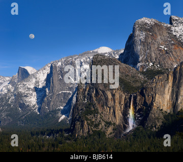 Yosemite Valley from Tunnel View with Half Dome moon and rainbow on Bridalveil Fall with blue sky Yosemite National Park California USA Stock Photo