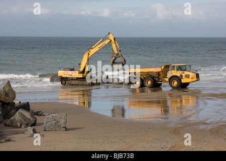 Moving boulders on the beach, tywyn Stock Photo