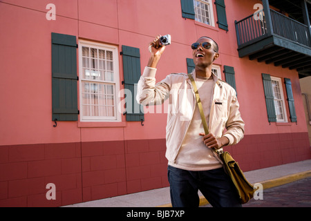 Young African-American male tourist with camera taking pictures Stock Photo
