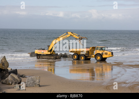 Moving boulders on the beach, tywyn Stock Photo