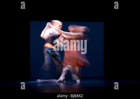 Two dancers captured in blurred movement in a modern ballet production. Stock Photo