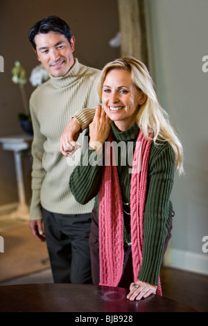 Cheerful couple wearing sweaters standing isolated over gray background