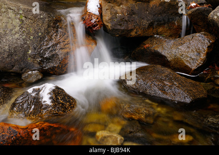 Cold waterfall and whirlpool with snow on rocks on Bridalveil Creek below the Fall in Yosemite Valley Stock Photo