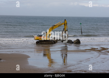 Moving boulders on the beach, tywyn Stock Photo