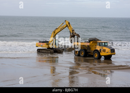 Moving boulders on the beach, tywyn Stock Photo