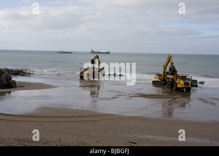 Moving boulders on the beach, tywyn Stock Photo