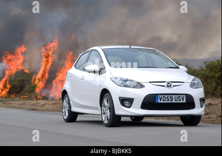 2010 Mazda 2 Sport 1.5 by controlled burning heath in New Forest Stock Photo