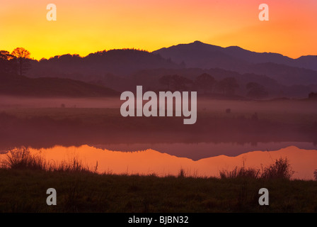 An amazing colorful sunset reflects in River Brathay, The Lake district National Park Stock Photo
