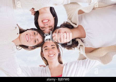 Hispanic women hugging in circle Stock Photo