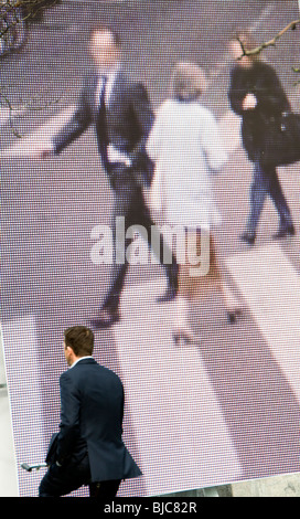 A man cycling past a large outdoor artwork in Amsterdam, the Netherlands Stock Photo