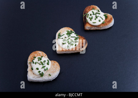 Three Heart-shaped portions of food, on black background Stock Photo