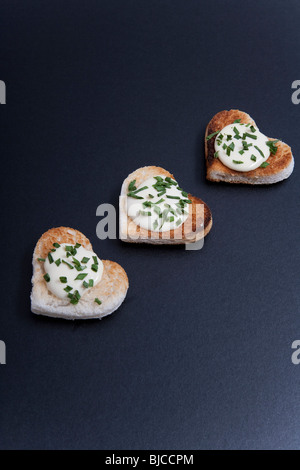 Three Heart-shaped portions of food, on black background Stock Photo