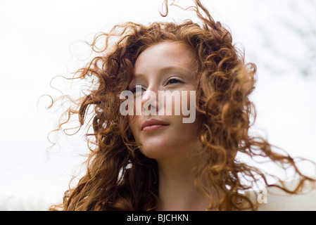 Young woman with tousled hair looking away in thought, portrait Stock Photo