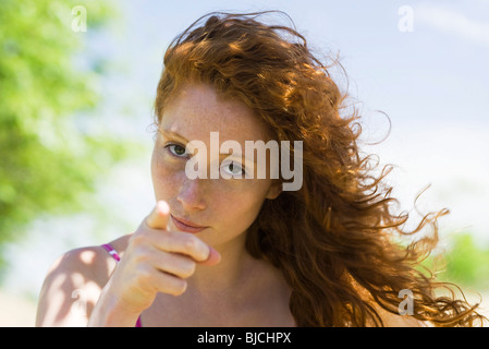Young woman with look of reproach pointing finger at camera Stock Photo