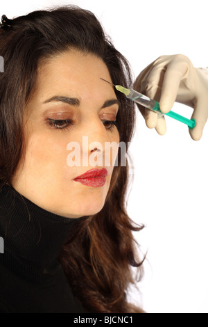 Young woman receives botox injection in her forehead - Close-up Stock Photo