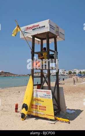 Lifeguard sits in a wooden platform overlooking Agios Georgios Beach in Naxos, Greece Stock Photo