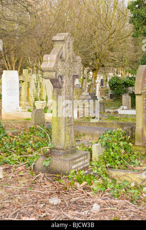 Highgate Cemetery , London , random headstones & graves in disrepair with Celtic cross symbolizing immortality Stock Photo