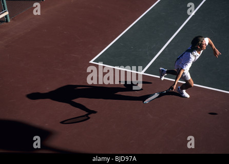 Tennis player in action on a hard court Stock Photo