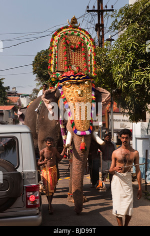 India, Kerala, Kochi, Ernakulam Shiva Temple, Uthsavom festival, caparisoned elephant led by priest through traffic Stock Photo