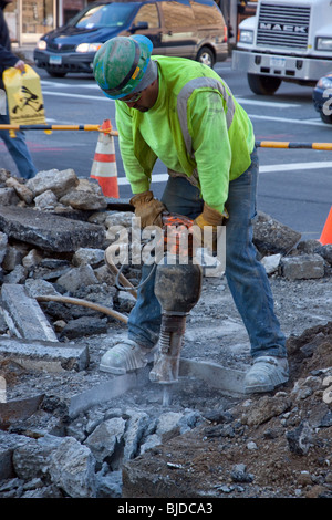 Adult male road maintenance worker using a jackhammer. Stock Photo