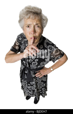 Senior woman shushing camera. Stock Photo