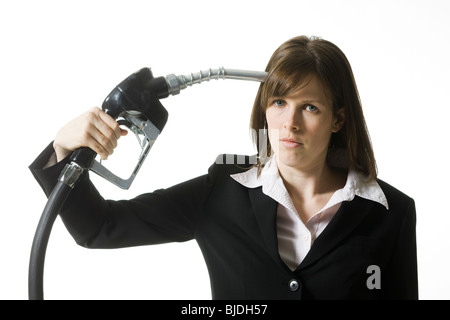 woman holding a gas pump to her head Stock Photo