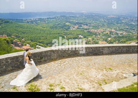 Bride and groom walking together in front of an Italian landscape Stock Photo