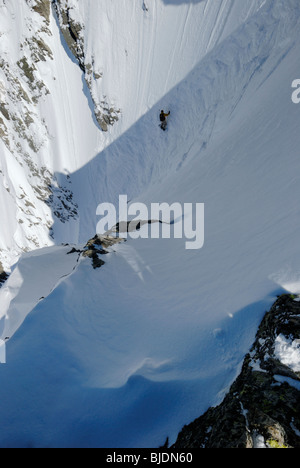 Snowboarder entering a very steep gully near Le Brevent-Flegere ski resort, Chamonix, France Stock Photo