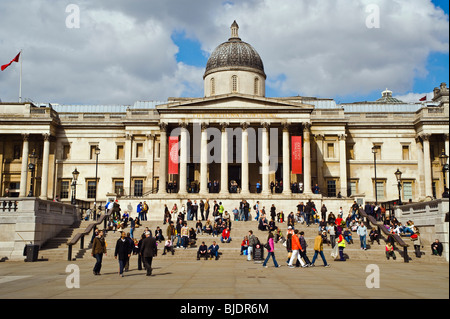 A busy scene on the steps of the National Gallery in Trafalgar Square, London Stock Photo